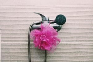 Kleine Reinigungsbürste wird an einem Duschkopf verwendet