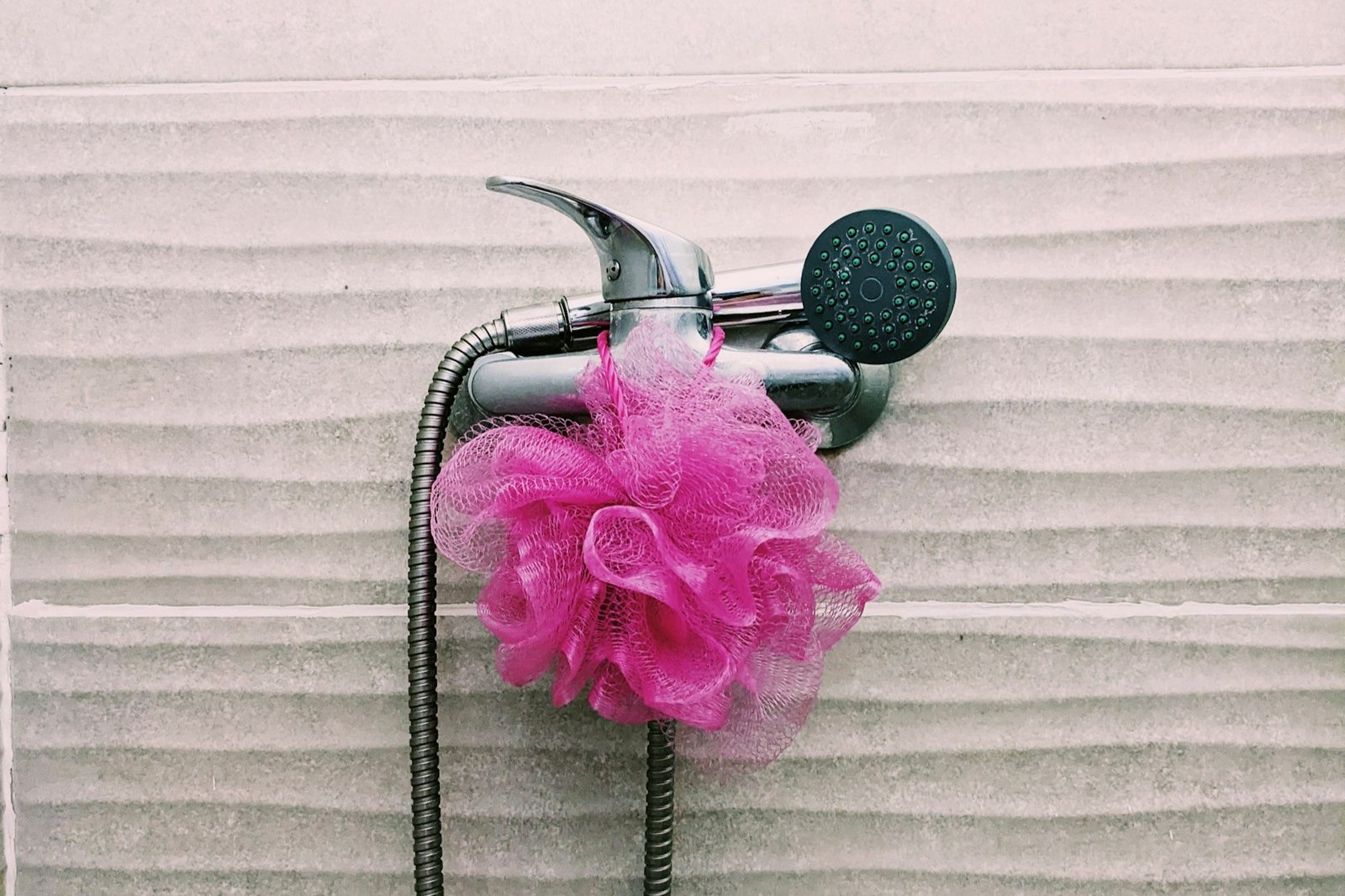 Kleine Reinigungsbürste wird an einem Duschkopf verwendet