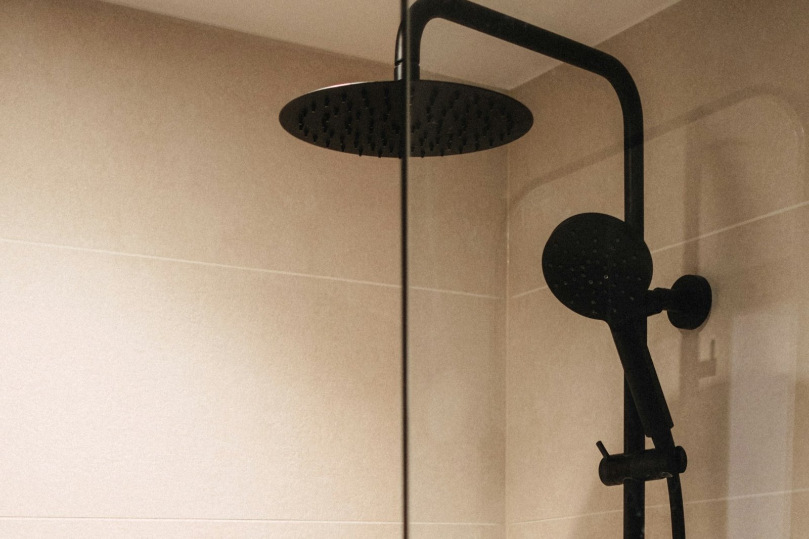 Nahaufnahme eines Duschkopfs mit dunklen Ablagerungen in den Düsen